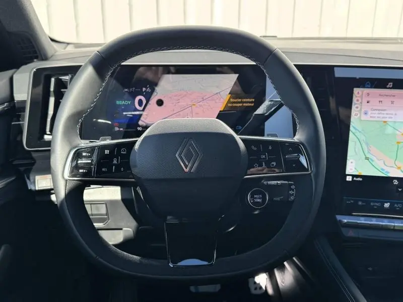 Vue centrée sur le volant noir du Renault Austral 2025 avec tableau de bord numérique et écran tactile latéral.