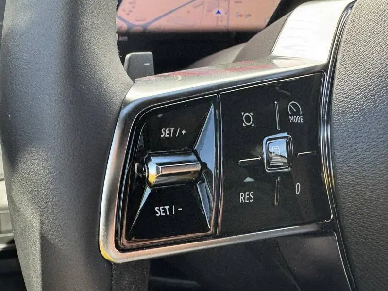 Gros plan sur les commandes de régulateur de vitesse au volant du Renault Austral blanc nacré 2025.