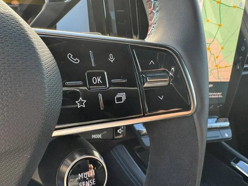 Gros plan sur les commandes multifonctions du volant du Renault Austral blanc nacré avec écran tactile et molette Multi Sense.