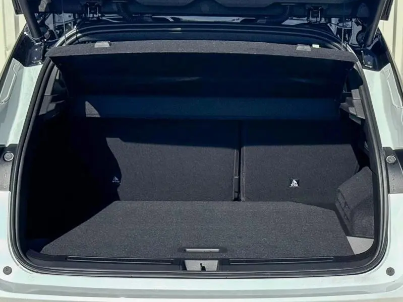 Coffre ouvert vu de l'arrière du Renault Austral blanc nacré brillant, montrant un espace de chargement propre et spacieux.