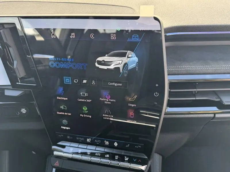 Écran tactile central du tableau de bord du Renault Austral blanc nacré, affichant les options de conduite et confort.