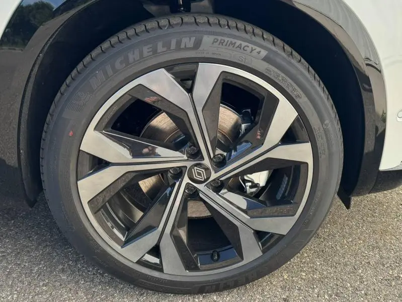 Gros plan sur la roue avant gauche du Renault Austral blanc nacré brillant, mettant en valeur la jante alu design et le pneu Michelin.