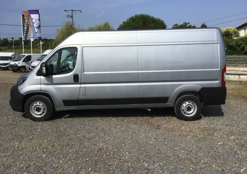 Profil côté gauche d'un utilitaire Peugeot Boxer Fourgon gris Artense, vue latérale sans fenêtres arrière.