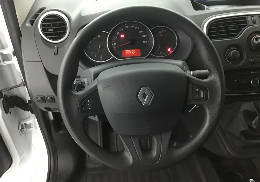 Vue intérieure centrée sur le volant noir du Renault Kangoo blanc 2021 avec tableau de bord et commandes visibles.