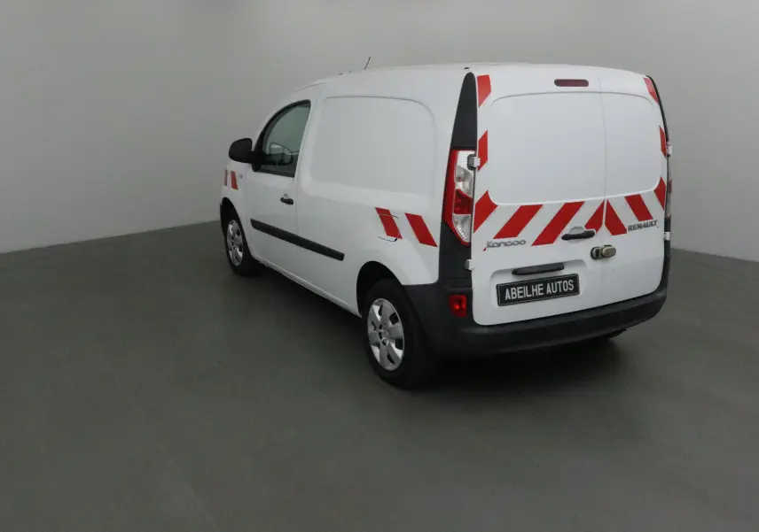 Vue 3/4 arrière droite d'un Renault Kangoo blanc 2021 avec bandes réfléchissantes rouges et blanches sur la carrosserie.