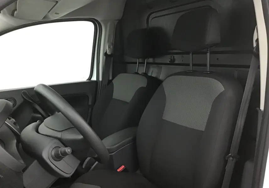 Vue intérieure côté conducteur du Renault Kangoo blanc 2021, montrant les sièges avant en tissu gris et noir.