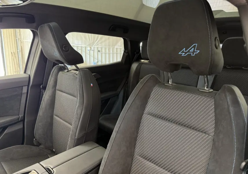 Vue intérieure côté droit des sièges avant en suède gris foncé avec logo Alpine brodé sur appuie-tête du Renault Espace 2025.