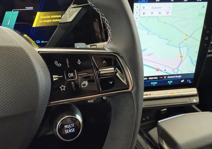 Gros plan sur le volant cuir et suede avec commandes multifonctions, et écran tactile de navigation du Renault Espace gris foncé esprit Alpine.