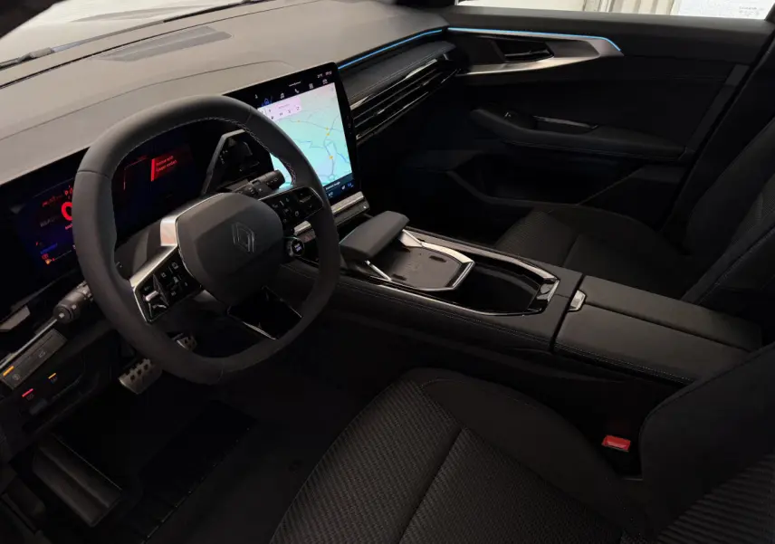 Intérieur avant côté conducteur du Renault Espace gris foncé 2025 avec volant cuir et grand écran tactile central.