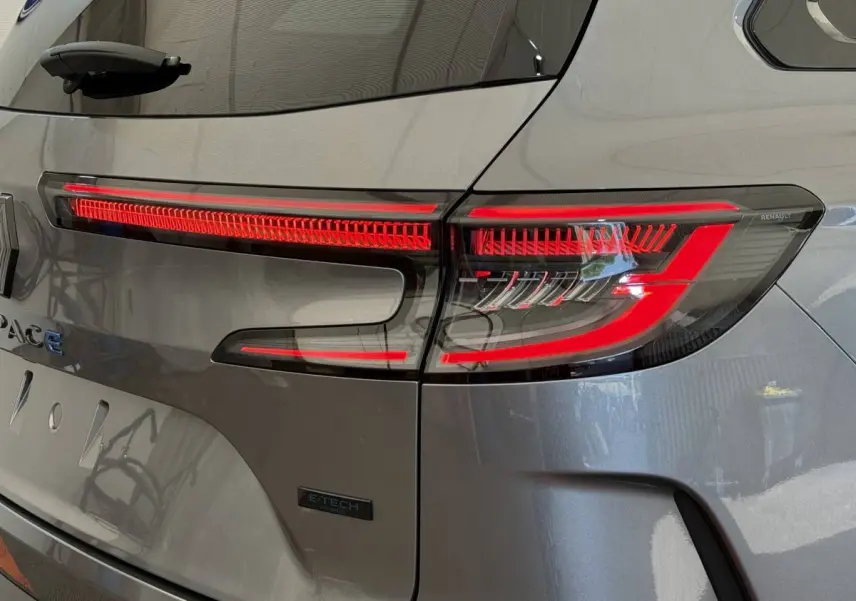 Gros plan sur le feu arrière droit rouge d'un Renault Espace gris foncé hybride E-Tech 2025.