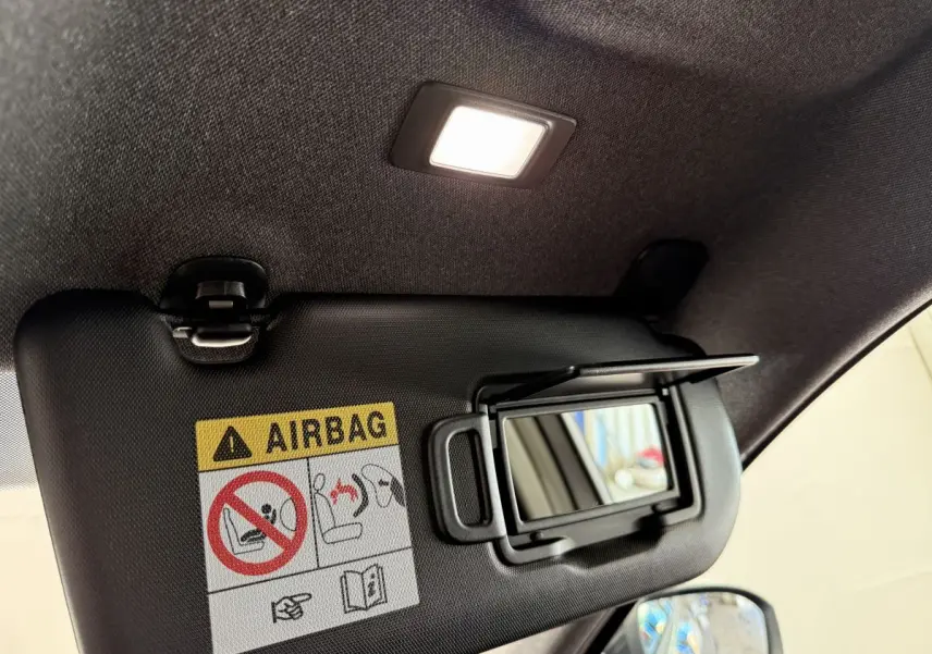 Détail du pare-soleil avec miroir et avertissement airbag dans l'habitacle du Renault Espace gris foncé 2025.