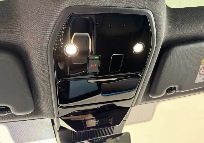 Vue en contre-plongée du panneau de commande de toit noir brillant avec bouton SOS et éclairages intégrés dans un Renault Espace gris foncé 2025 esprit Alpine.