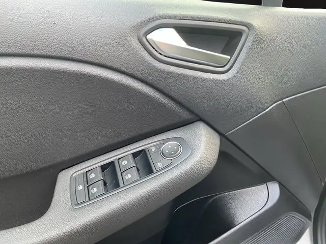 Détail de la porte avant gauche de la Renault Clio V gris Highland, avec commandes des vitres et rétroviseurs.