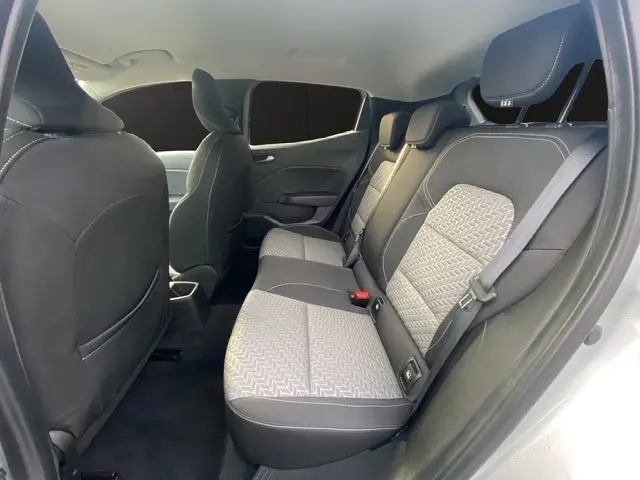 Vue intérieure arrière droite de la Renault Clio V gris Highland, montrant les sièges arrière en tissu noir et beige avec vitres surteintées.