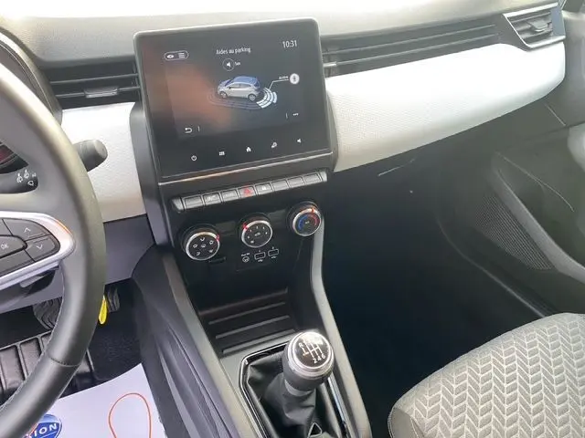 Vue intérieure de la Renault Clio V TCE 90 Evolution, tableau de bord avec écran tactile et levier de vitesse manuelle.