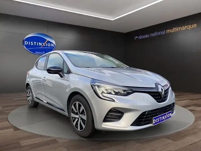 Renault Clio V TCE 90 Evolution gris Highland en 3/4 avant droit, vitres arrière surteintées et projecteurs Full LED.