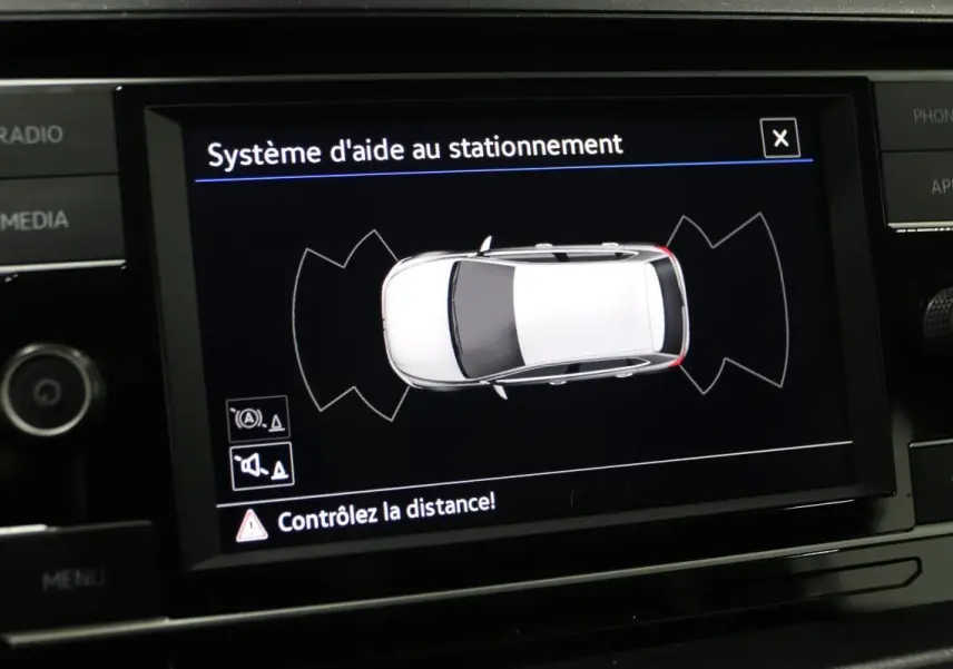Écran central affichant le système d'aide au stationnement avec vue aérienne d'une Volkswagen Polo blanche.