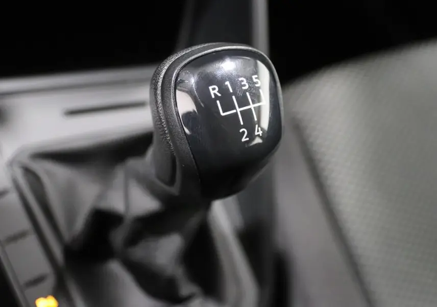 Gros plan sur le levier de vitesses manuel noir de la Volkswagen Polo 1.0 80 BVM, intérieur tissu gris.