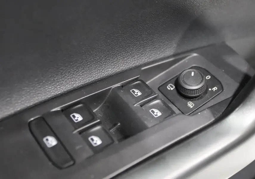 Commande des vitres électriques et réglage des rétroviseurs sur la porte côté conducteur d'une Volkswagen Polo blanche 2022.