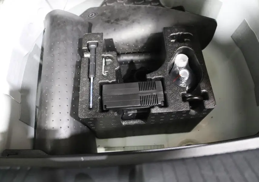 Coffre ouvert d'une Volkswagen Polo blanche 2022, montrant le rangement d'outils et accessoires sous le plancher.