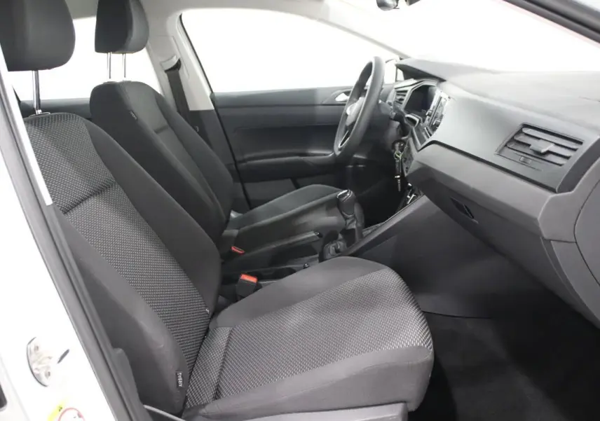 Vue intérieure côté gauche de la Volkswagen Polo blanche 2022, montrant les sièges tissu noirs et le tableau de bord.