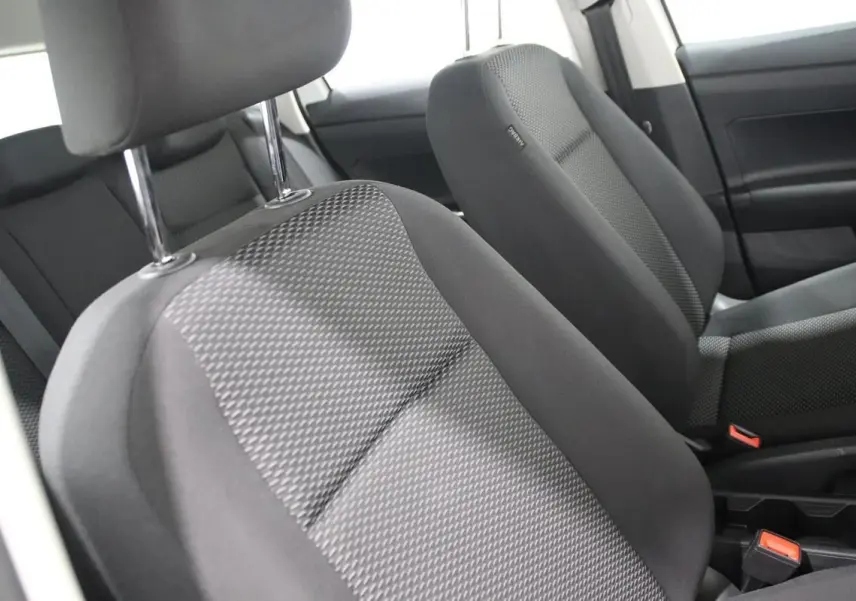Gros plan sur les sièges avant en tissu gris de la Volkswagen Polo 1.0 80 BVM, intérieur sobre et fonctionnel.