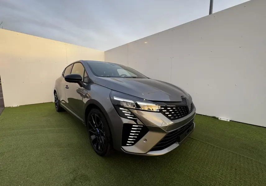 Renault Clio V hybride gris schiste métal vue 3/4 avant droit avec feux LED et jantes noires distinctives.