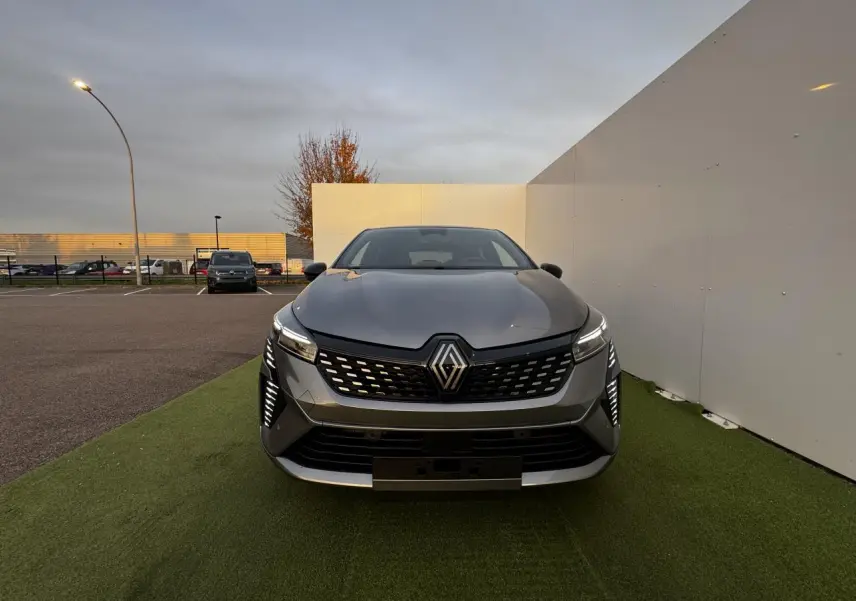 Vue frontale d'une Renault Clio 2025 gris schiste métal avec feux LED et calandre noire ajourée.