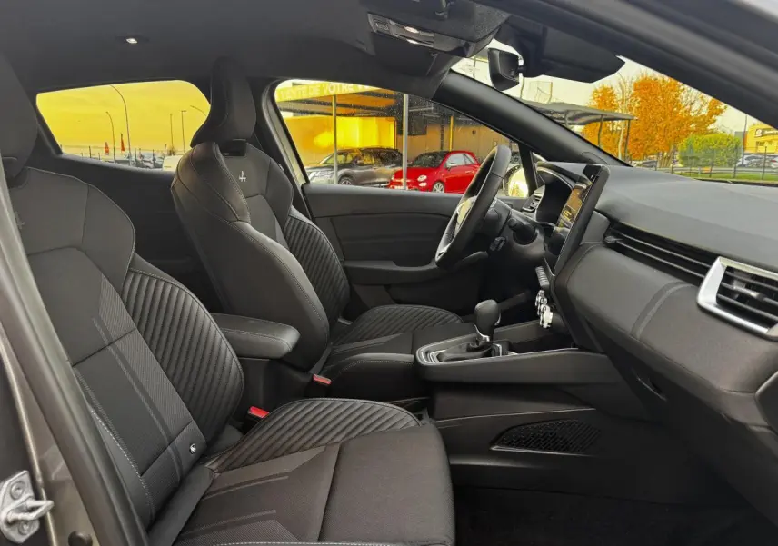 Vue intérieure côté conducteur de la Renault Clio gris schiste avec sièges sport noirs et volant multifonction