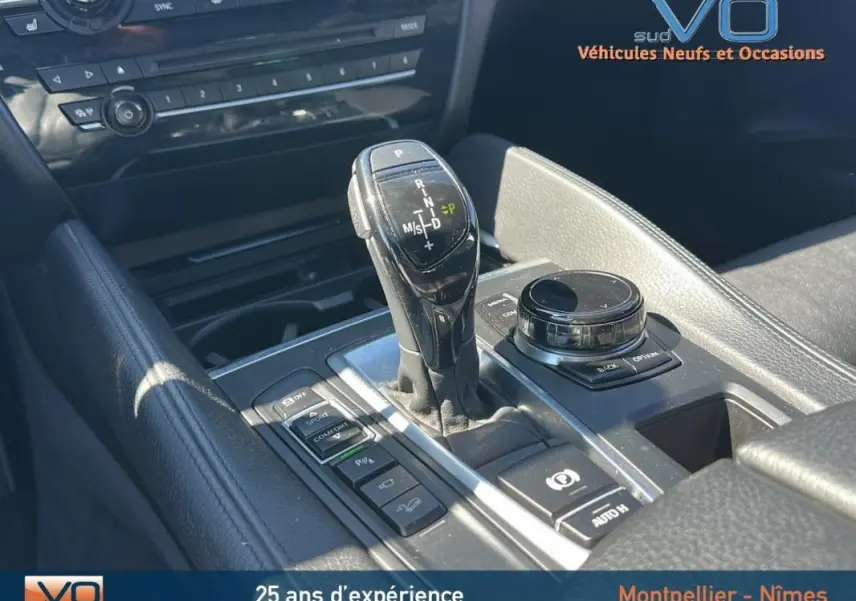 Vue rapprochée de la console centrale noire du BMW X6 F16 xDrive40d avec levier de vitesses automatique et commandes M Sport.