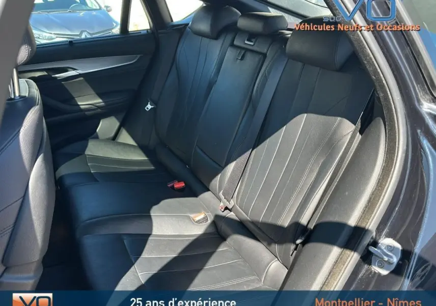 Vue intérieure côté droit des sièges arrière en cuir noir du BMW X6 F16 xDrive40d 2017, avec ceinture de sécurité et appuie-têtes visibles.