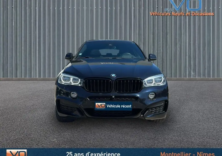 Vue frontale d'un BMW X6 noir F16 xDrive40d 2017 avec phares allumés et calandre noire caractéristique M Sport.