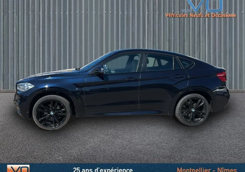 Profil droit d’un BMW X6 noir F16 xDrive40d 2017 avec jantes alliage noires et silhouette sportive coupé SUV.