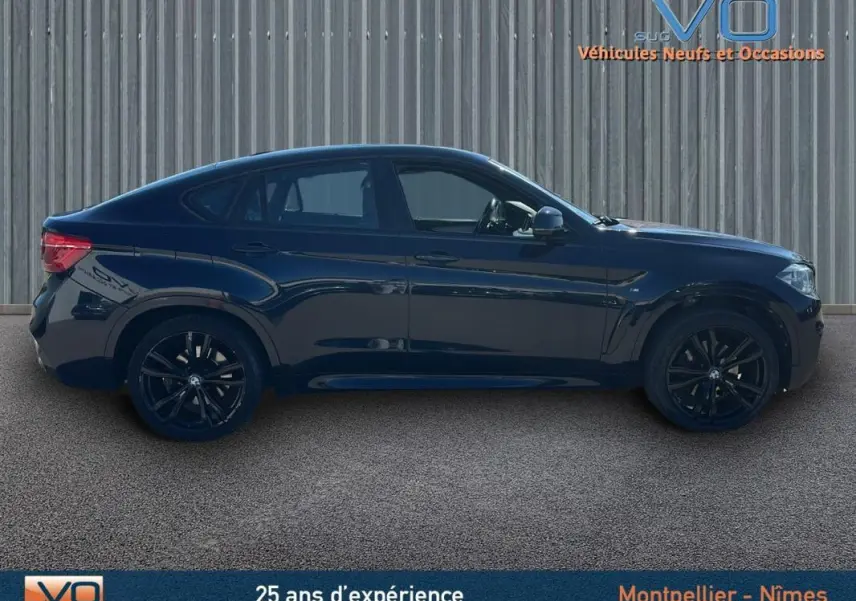 Profil côté gauche d'un BMW X6 noir F16 xDrive40d 2017 avec jantes alliage noires et silhouette sportive M Sport.