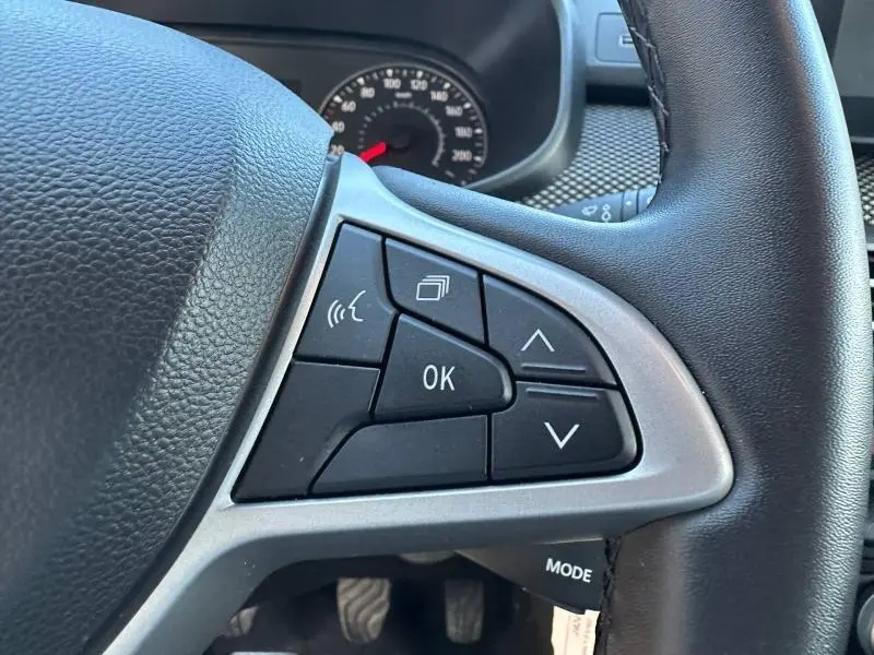 Gros plan sur les commandes au volant côté gauche du Dacia Jogger 2025, boutons multifonctions noirs avec contour argenté.