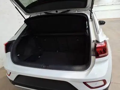 Vue arrière ouverte du coffre du Volkswagen T-Roc blanc 2025, mettant en valeur l'espace de chargement intérieur.