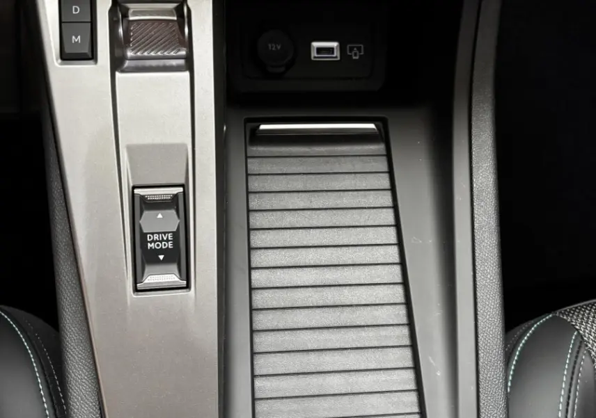 Vue rapprochée de la console centrale intérieure de la Peugeot 308 Hybrid 145 e-DCS6 Allure avec commandes de boîte auto et frein à main électrique.