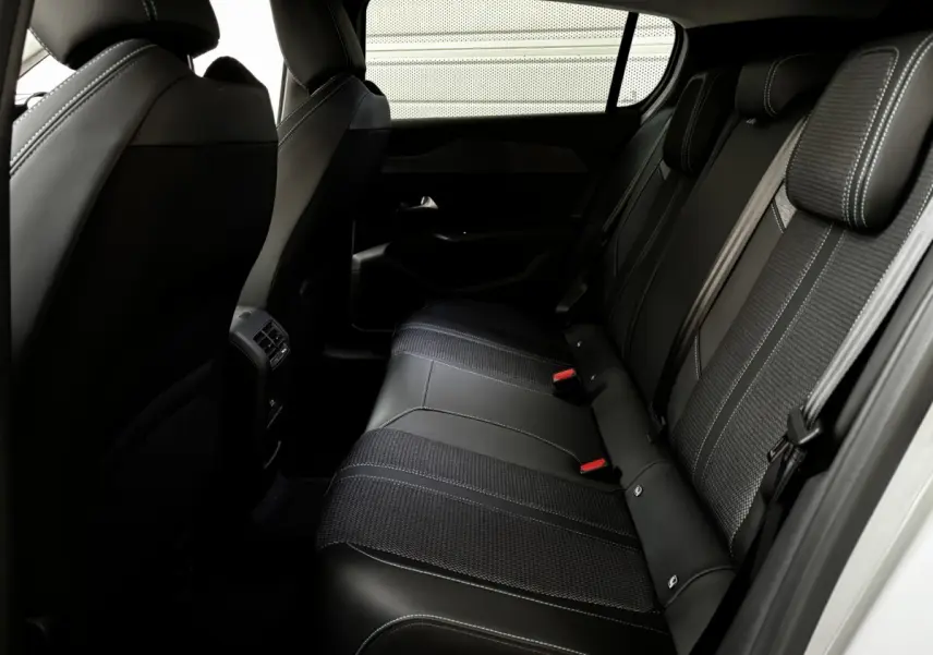 Vue intérieure côté droit des sièges arrière noirs en cuir et tissu de la Peugeot 308 Hybrid 145 e-DCS6 Allure 2025.