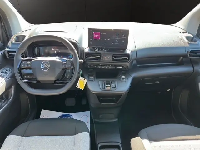 Vue intérieure avant du Citroën Berlingo N1 BlueHDi 130 2025, tableau de bord noir avec écran central tactile et volant multifonction.