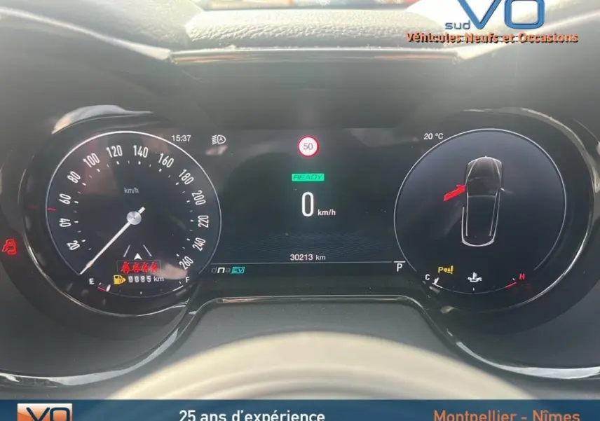 Tableau de bord numérique d'Alfa Romeo Tonale rouge 2024, affichage vitesse, température et alertes visibles.