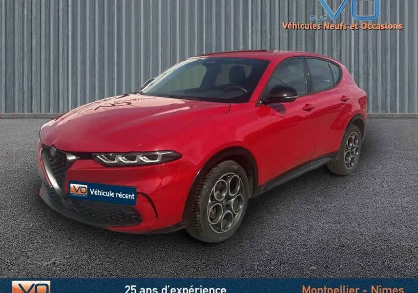 Vue 3/4 avant d'un Alfa Romeo Tonale rouge 2024 avec jantes distinctives et rétroviseurs noirs sur sol gris.