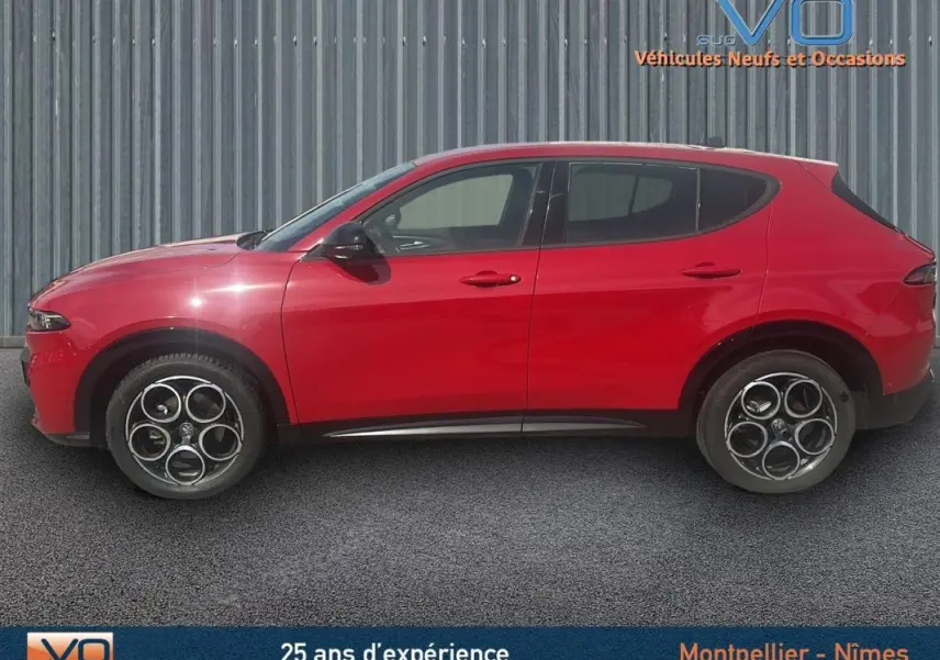 Vue latérale droite d'une Alfa Romeo Tonale rouge 2024 avec jantes distinctives et lignes profilées élégantes.