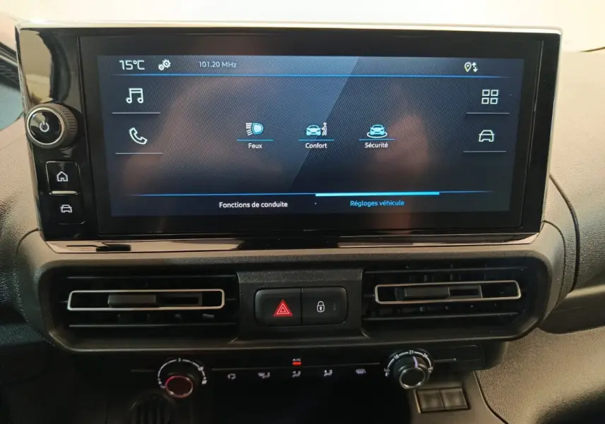 Écran tactile central du tableau de bord du Peugeot Partner blanc, avec commandes climatisation et alertes sécurité visibles.