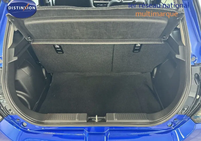 Coffre ouvert vu de l'arrière d'une Suzuki Swift 1.2 Pack Hybrid bleu 2024, montrant l'espace de chargement vide.