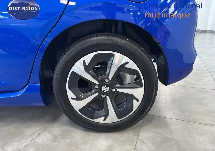 Gros plan sur la roue arrière droite d'une Suzuki Swift 1.2 Pack Hybrid 2024 bleu avec jante alliage au design moderne.