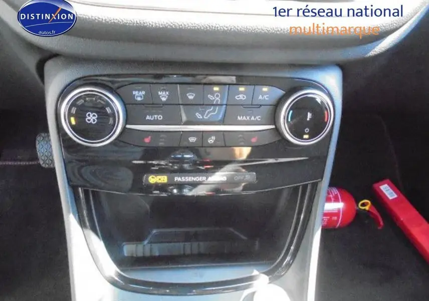 Vue rapprochée de la console centrale noire du Ford Puma 2022 avec commandes climatisation et rangement ouvert.