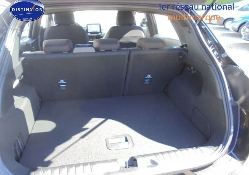 Coffre ouvert vu de l'arrière du Ford Puma noir 2022, montrant l'espace de chargement et les sièges arrière rabattables.