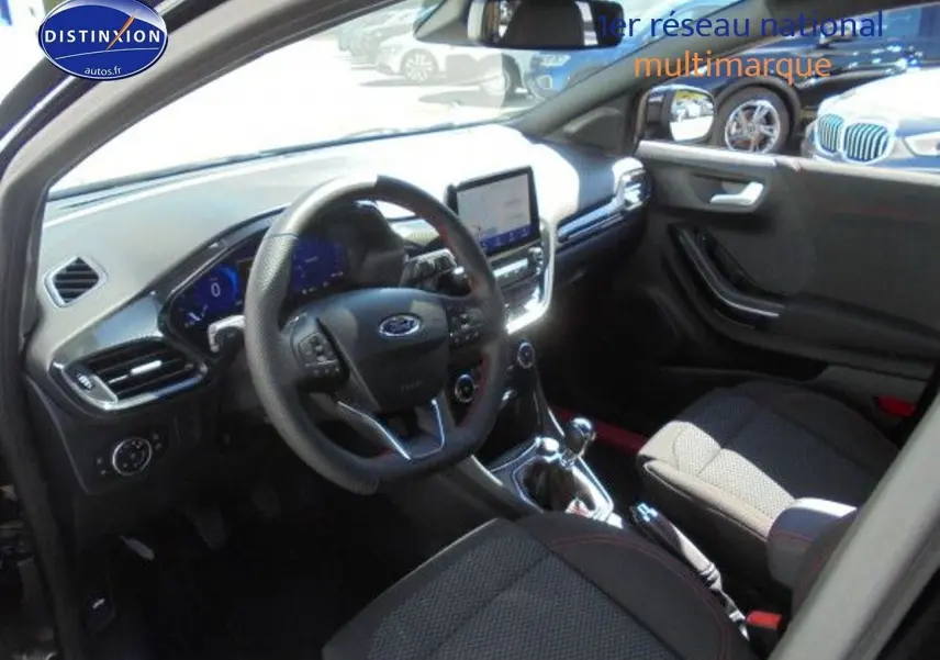 Vue intérieure côté conducteur du Ford Puma noir 2022, volant cuir multifonction et écran tactile central visible.