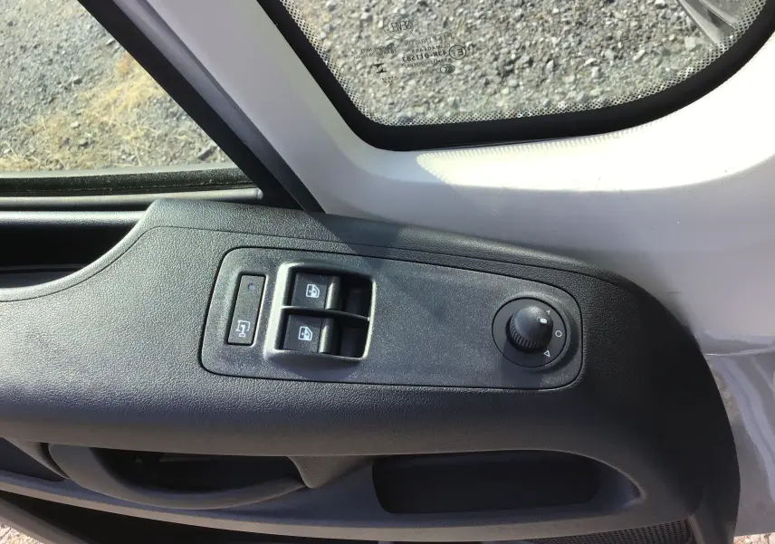Gros plan sur la commande des vitres et rétroviseurs côté gauche du Peugeot Boxer Fourgon gris Artense 2025.