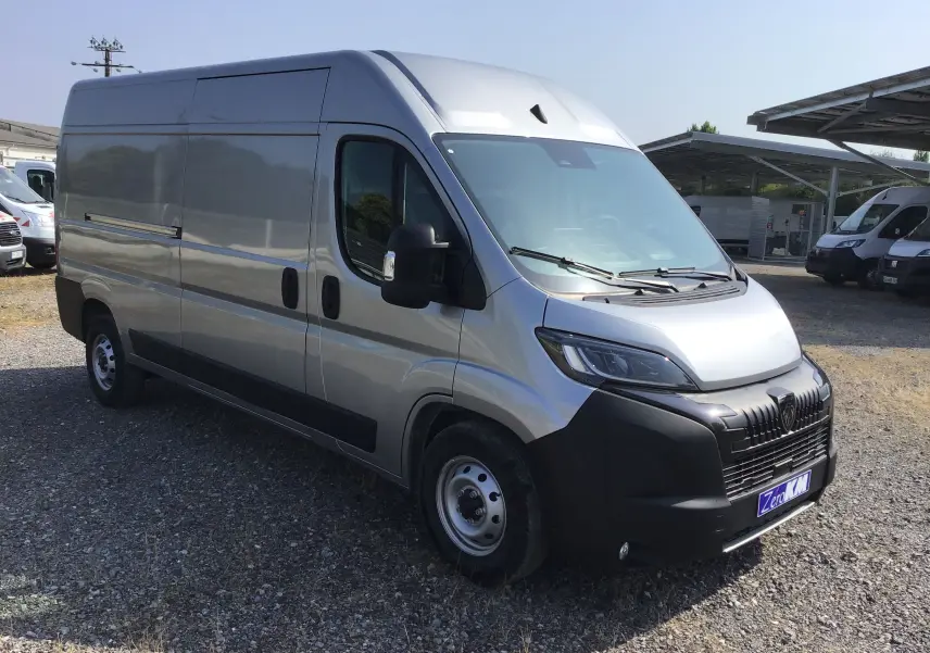 Peugeot Boxer Fourgon gris Artense vu en 3/4 avant droit, avec calandre noire et projecteurs LED visibles.